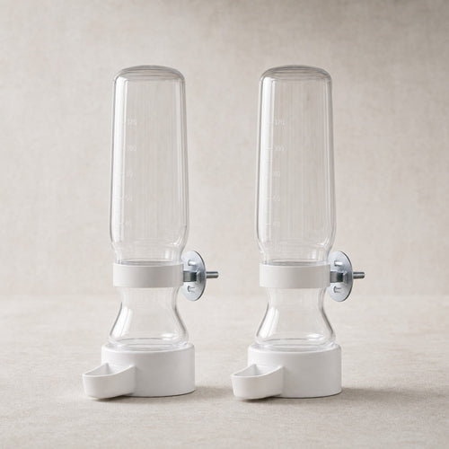 A pair of clear bird cage water feeders with white bases