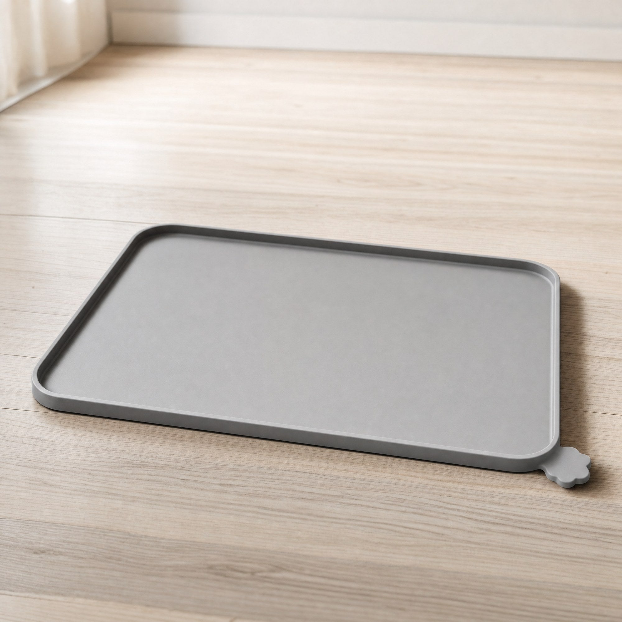 A grey silicone pet feeding mat with a raised lip